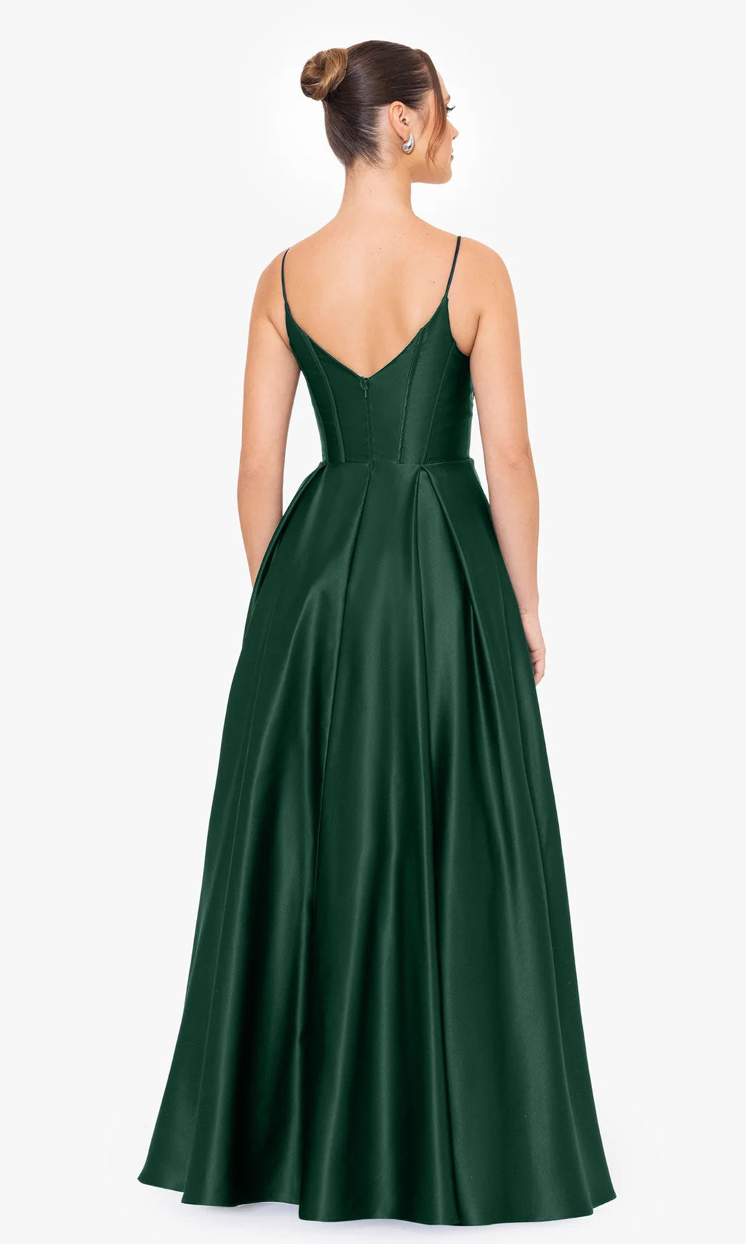 A woman is shown from the back wearing the Blondie Nites Long A-Line Prom Dress 4826BN, a floor-length dark green satin gown with thin straps, corset-style bodice, and flared skirt, against a plain white background.